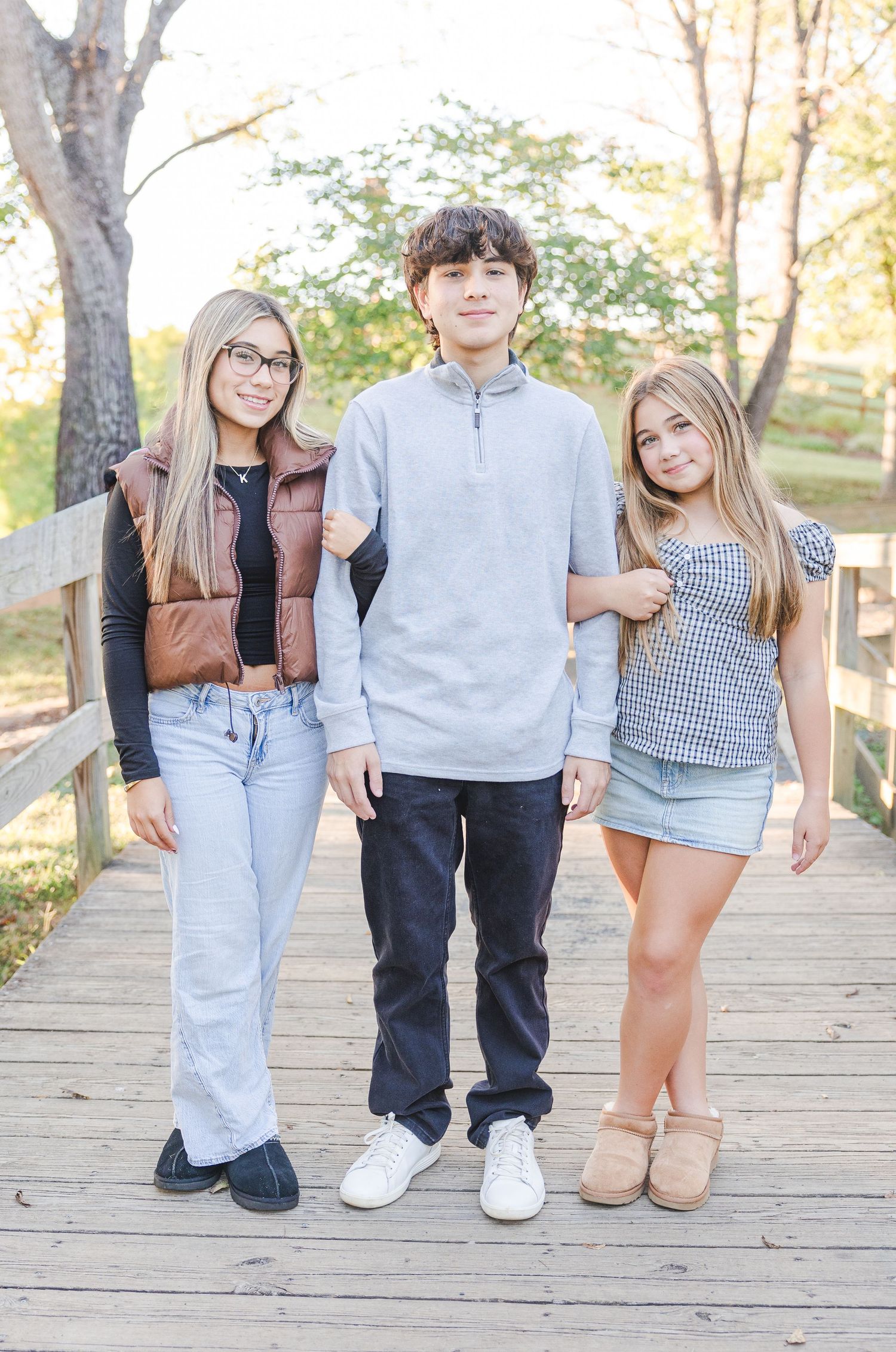 Casual group portrait showing legs and feet of people sitting on a wooden boardwalk in coordinated casual outfits.