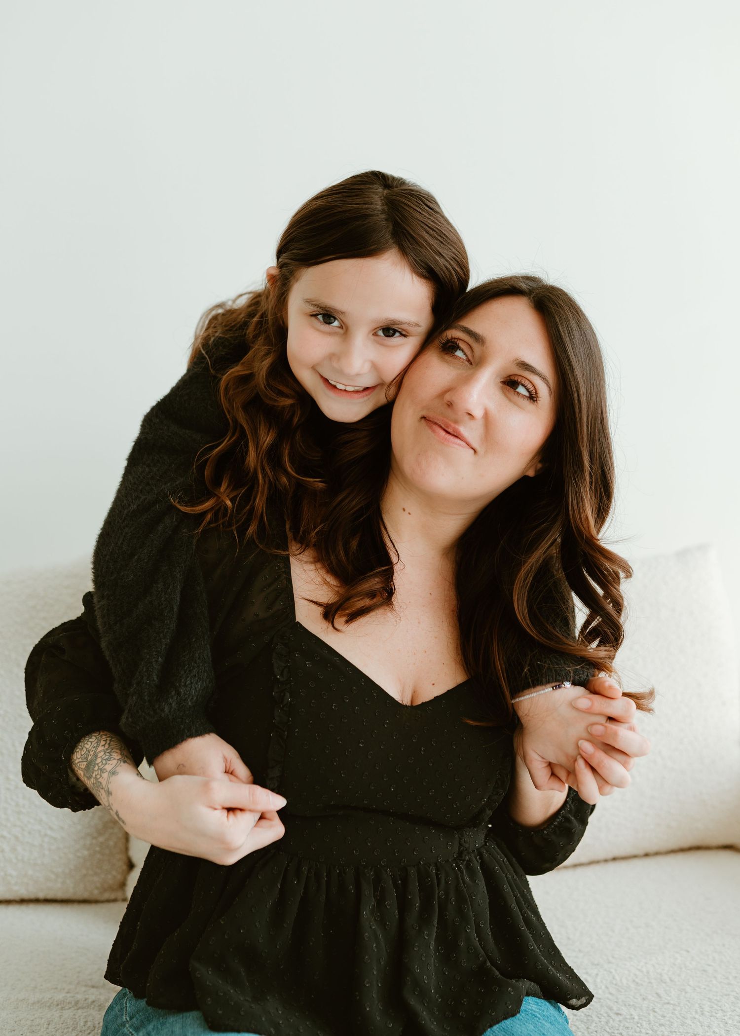 Lifestyle portrait on white couch with natural lighting.