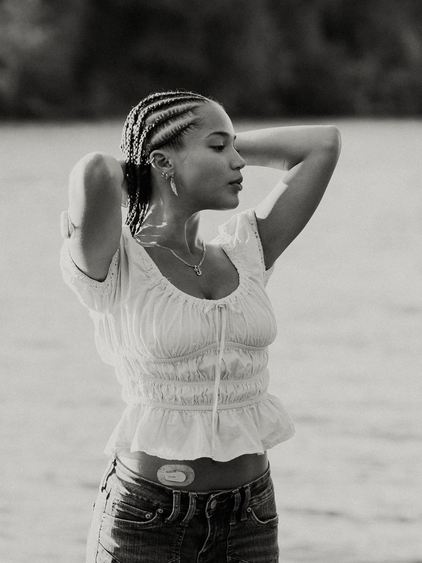A black and white fashion photo series shows a person in a white peasant top and dark pants posing against a light background.