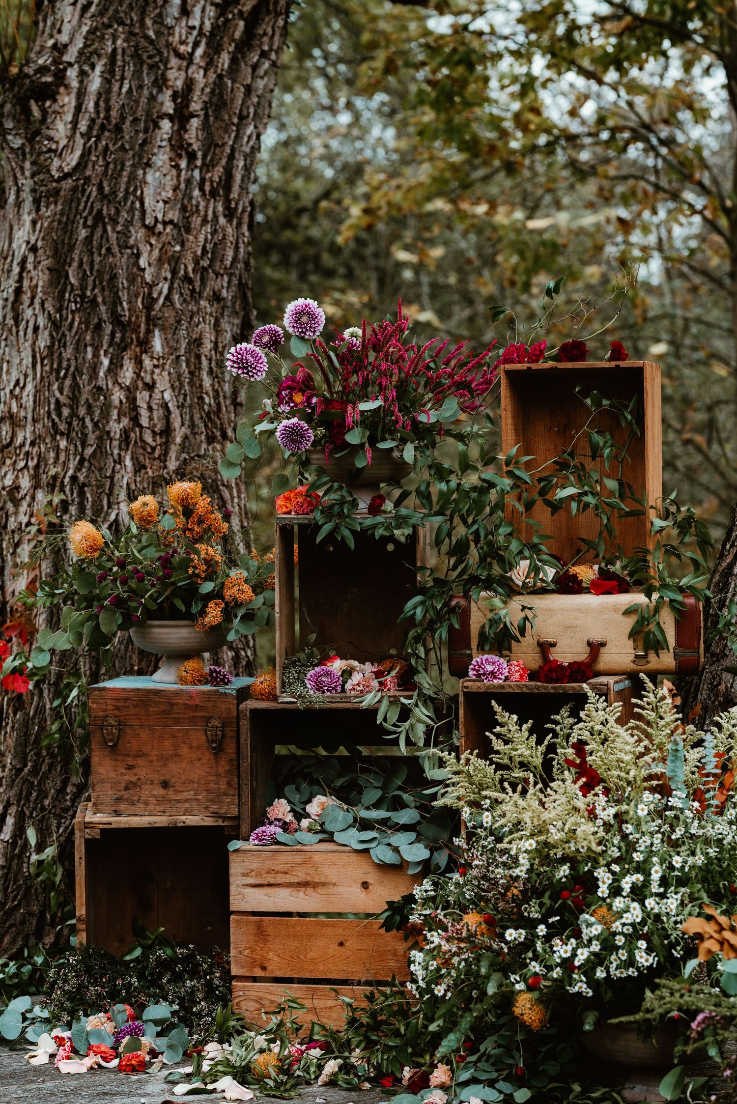 Rustic wooden crates filled with colorful flowers and greenery create a beautiful garden display.