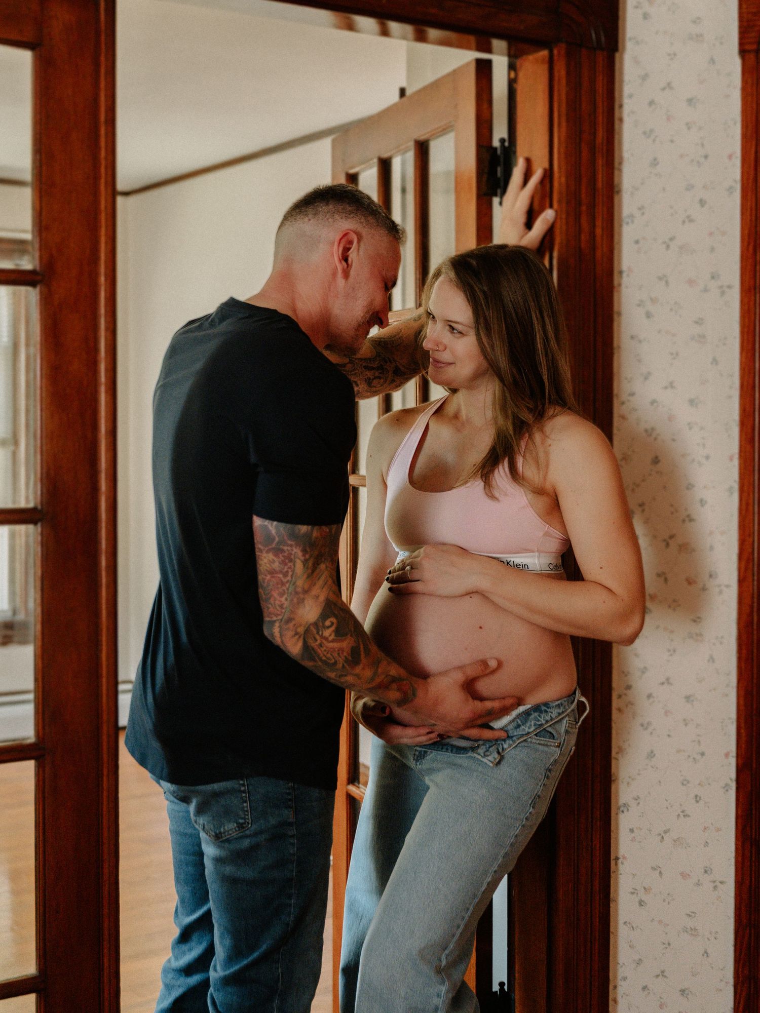 A romantic couple shares intimate moments in a series of photos against a wooden door frame in warm lighting.