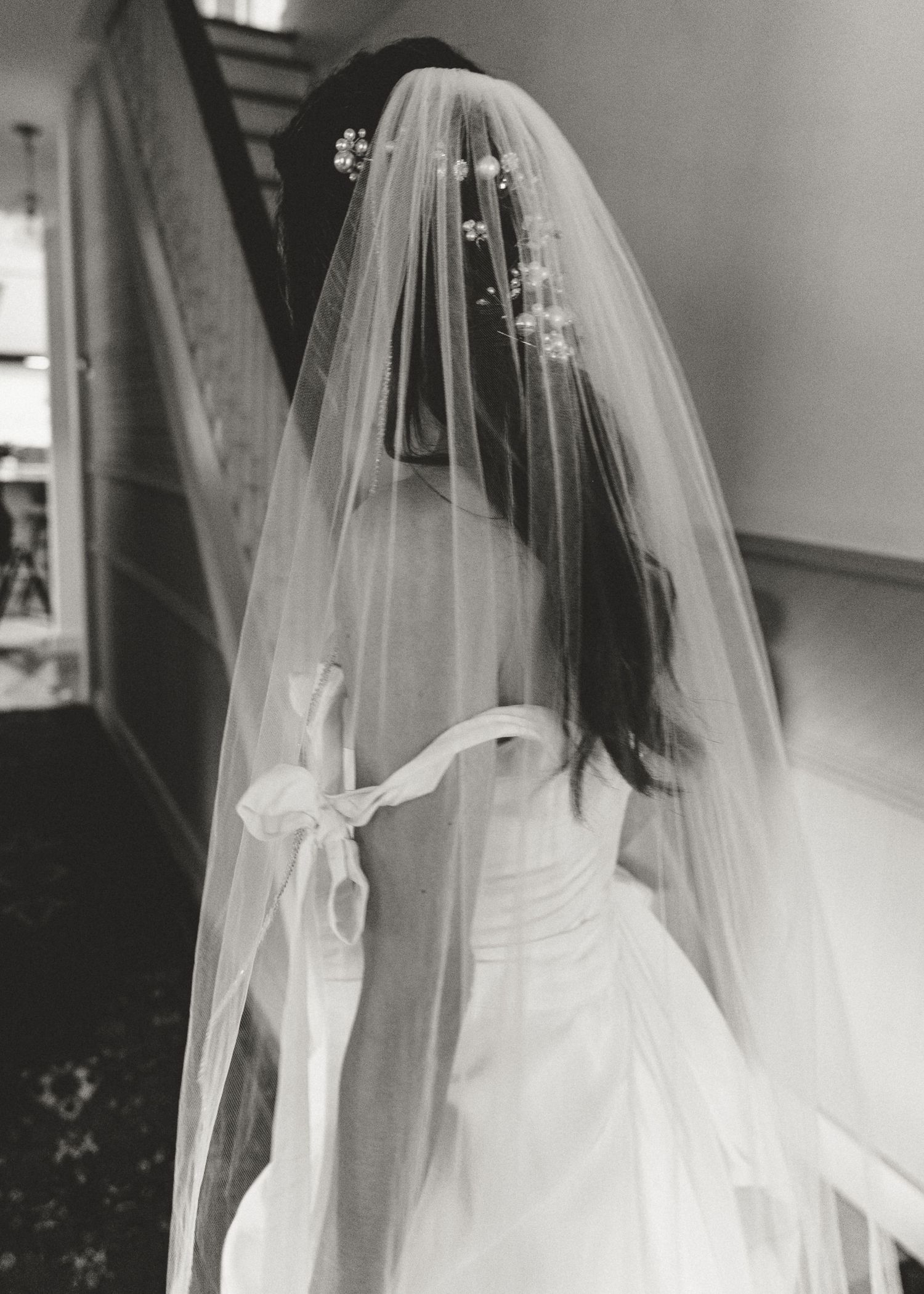 A series of black and white photos showing a bride in a flowing white wedding gown and veil from different angles.