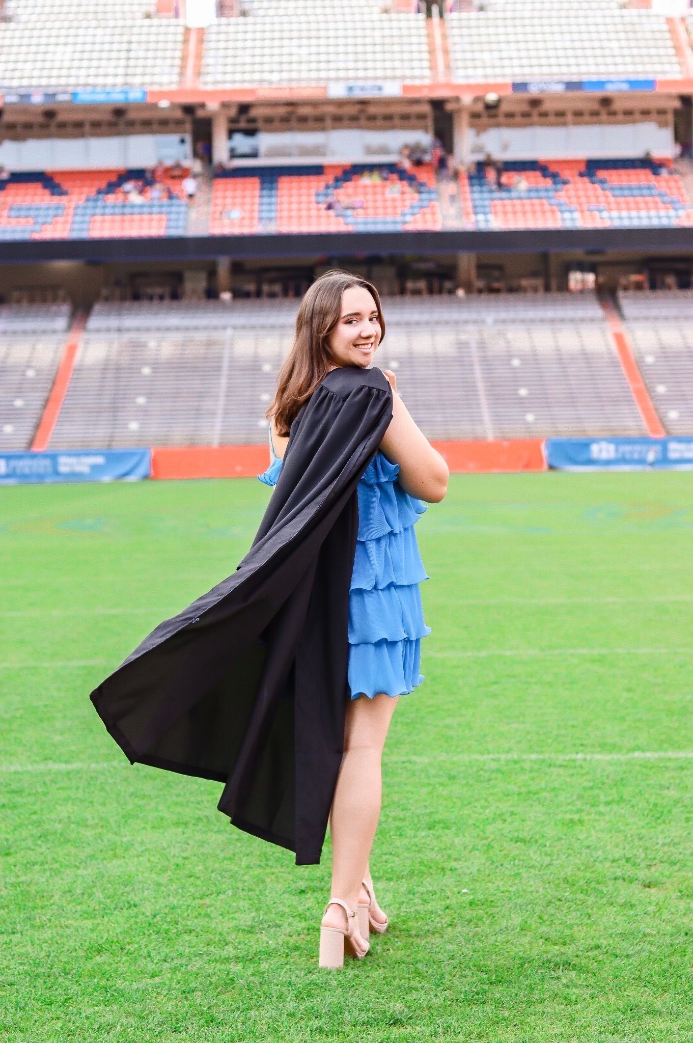 Graduate on football field with gown