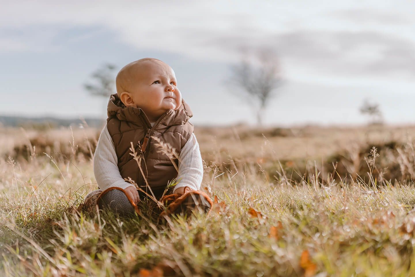 Babyfotografering i Gistrup taget udendørs i åbent landskab med naturligt lys.