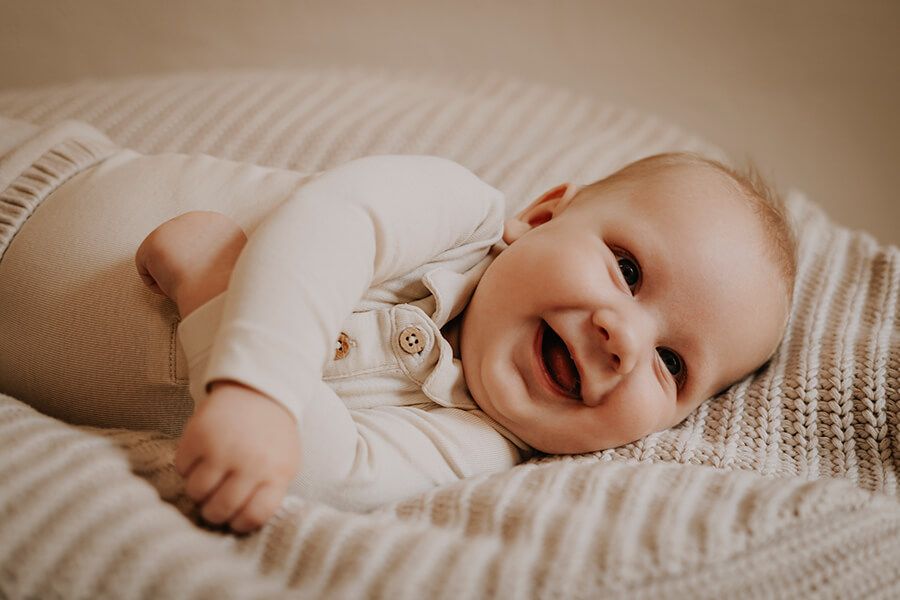 Glad baby fotograferet i naturligt lys af børnefotograf i Aalborg – JOEhansenFOTO.
