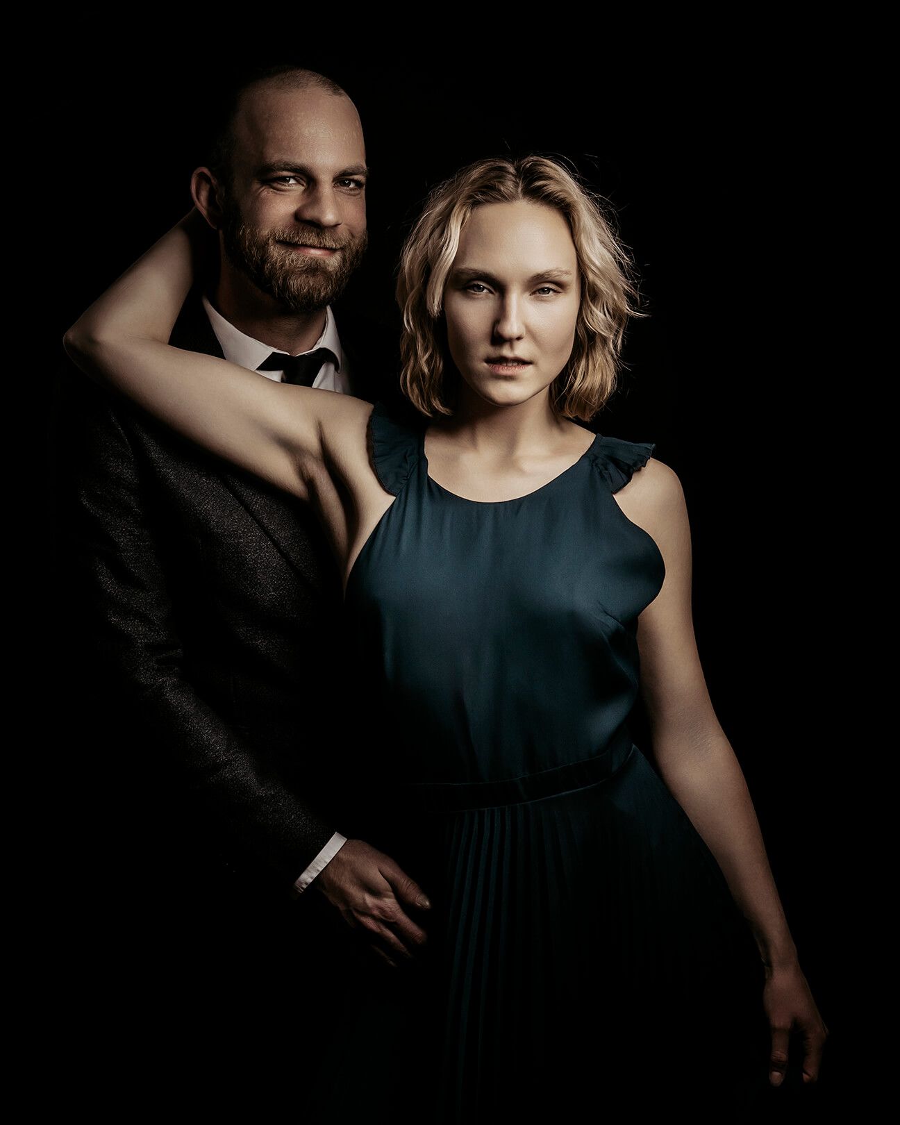 Mand og kvinde i tæt pose – modelfotografi med dramatisk lys og klassisk styling i Aalborg.