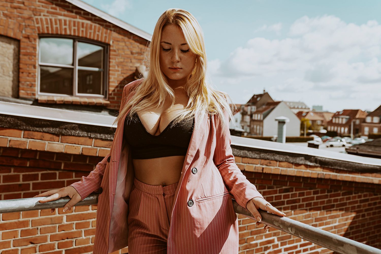 Modelfotograf Aalborg - En ung kvindelig model poserer i en kort top og jakkesæt, i solen på en repos, taget af fotograf i Aalborg, JOEhanse