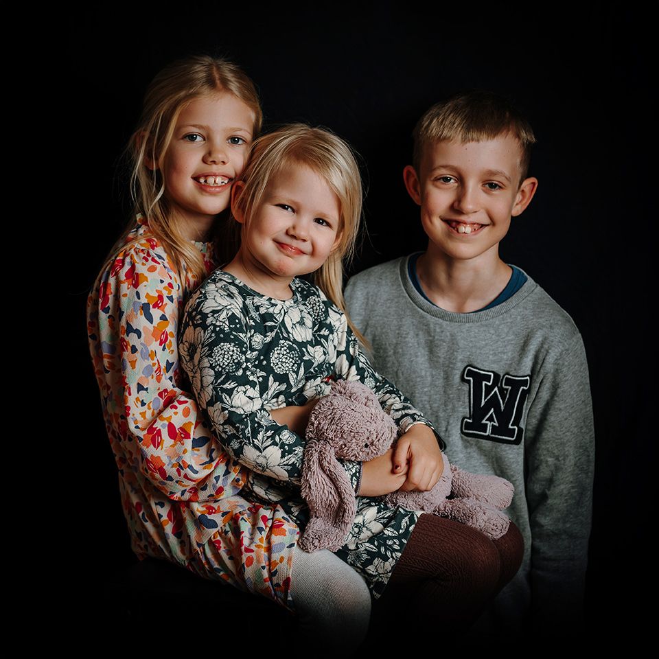 Familiefoto i Aalborg med tre børn og naturlige smil.