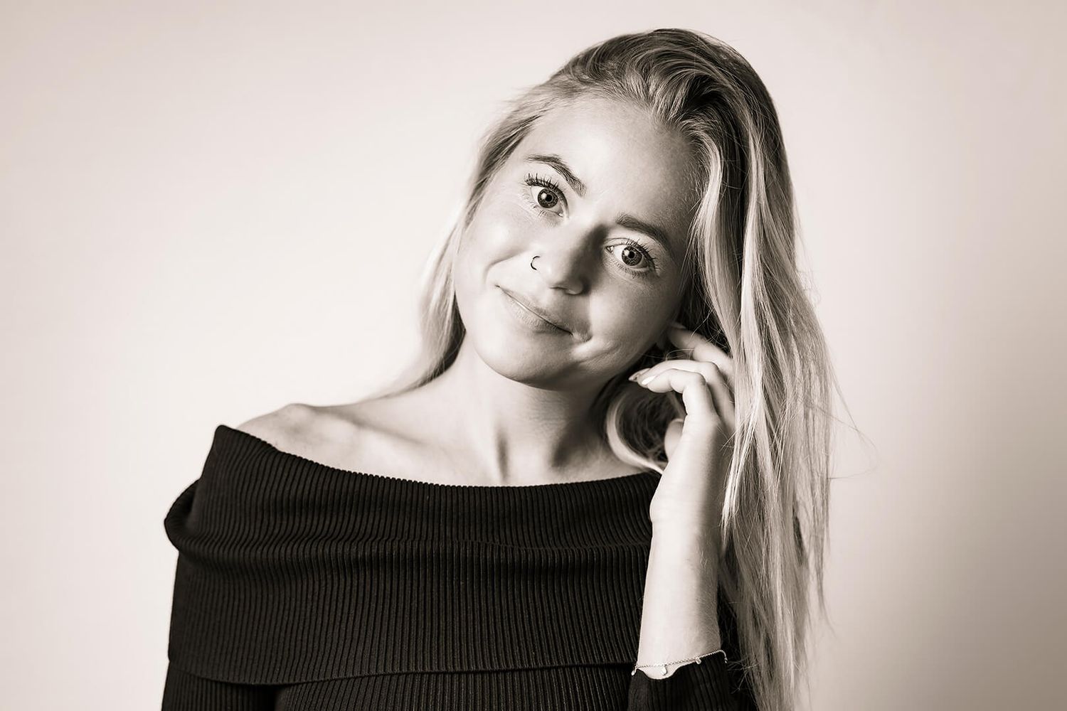 Fotograf Aalborg har taget et feminint modelportræt i naturligt lys med afslappet posering.