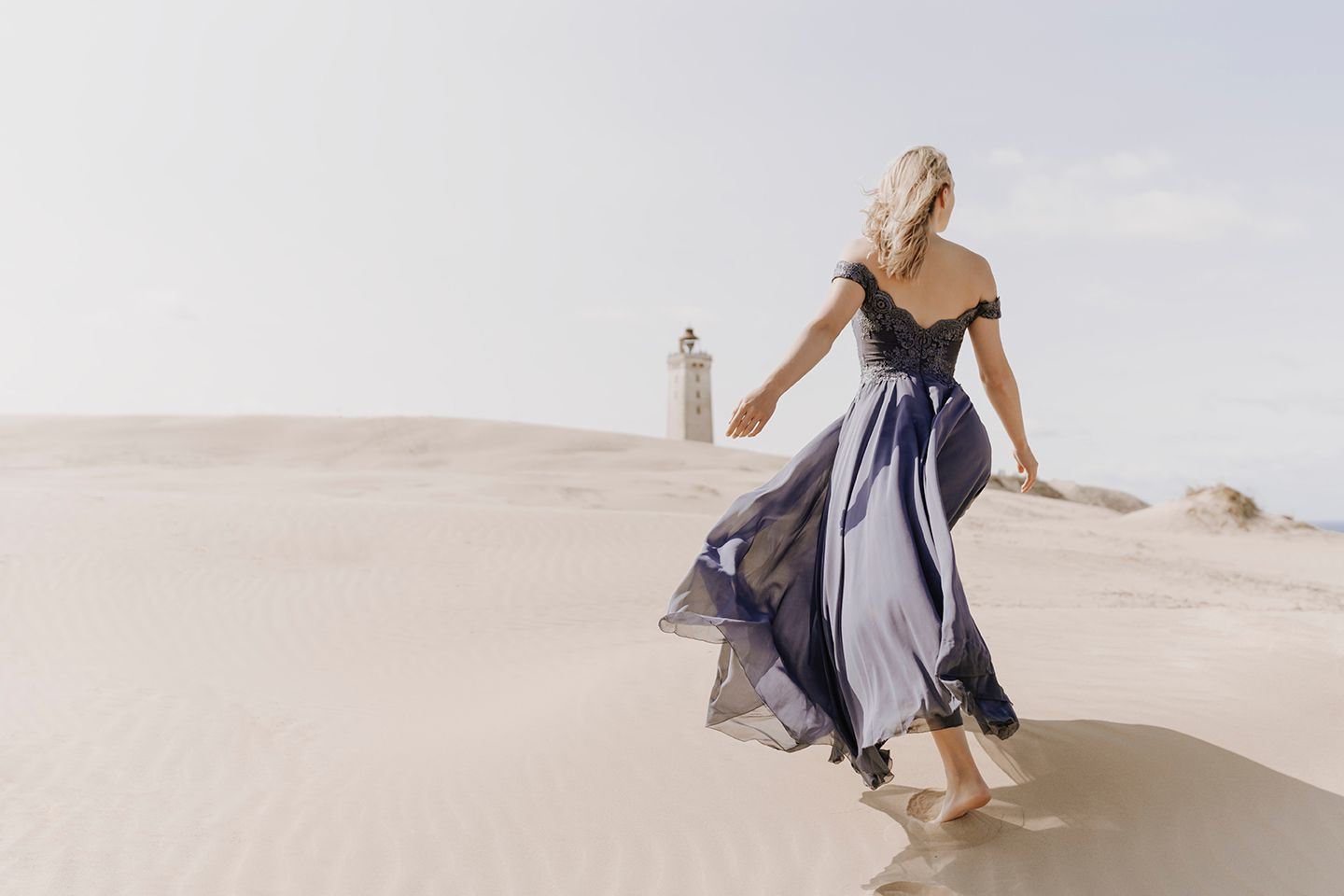 Modelfotograf Aalborg - En ung kvinde i lille kjole i sandet foran Rubjerg Fyr, taget af fotograf i Aalborg, JOEhansenFOTO.