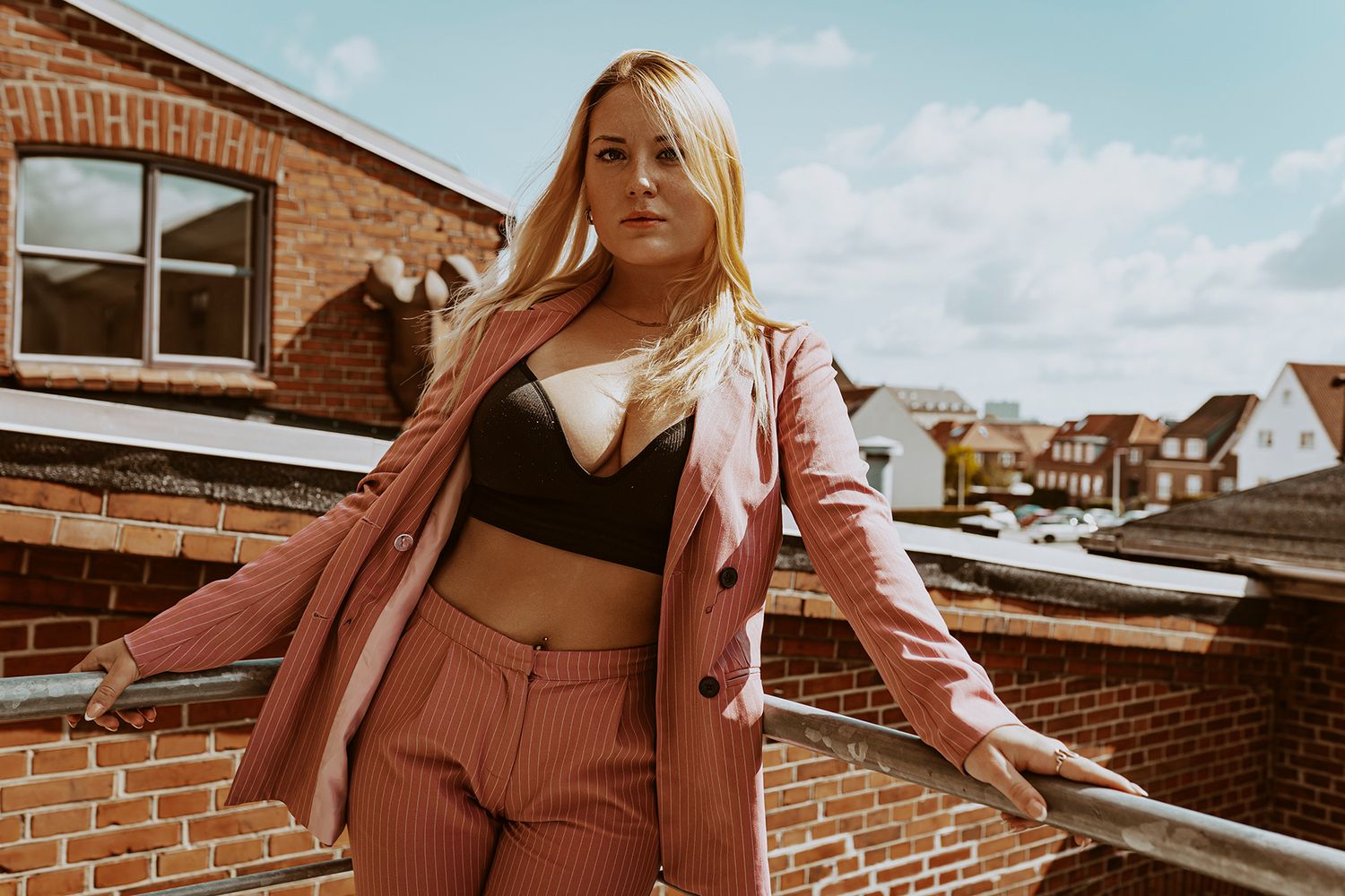 Flotte modelbilleder, her et portræt af en model, der står og læner sig op af et rækværk, taget af fotograf i Aalborg, JOEhansenFOTO.