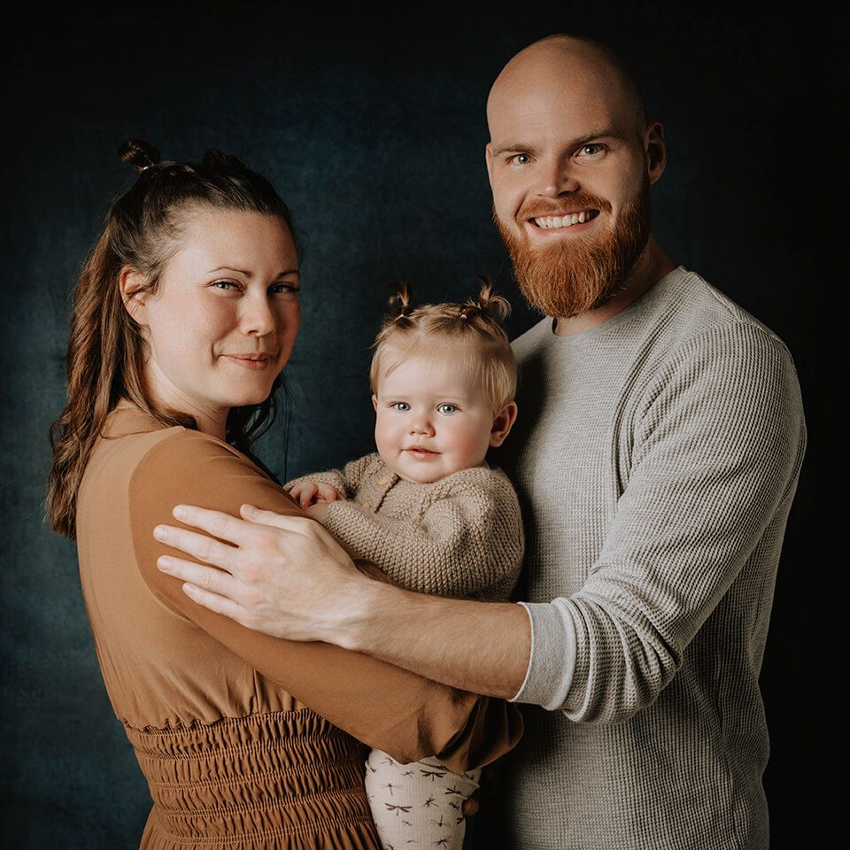 Familiefoto med forældre og barn taget i studie af fotograf i Aars.