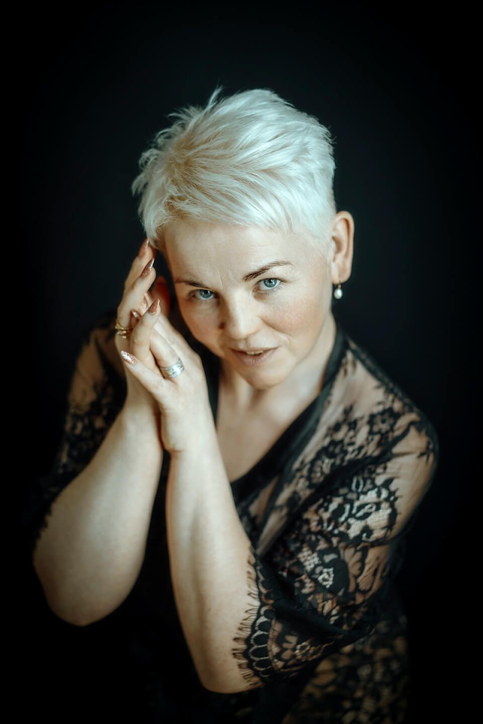 Sensuelt portræt af moden kvinde med kort blondt hår i sort blonde, fotograferet af boudoirfotograf i Aalborg.