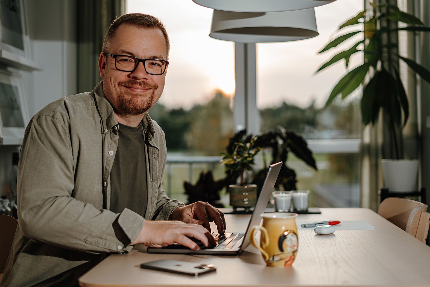 Portrætfotograf Aalborg - Et portræt af fotografen, der sidder og arbejder ved sit spisebord, taget af fotograf i Aalborg, JOEhansenFOTO.