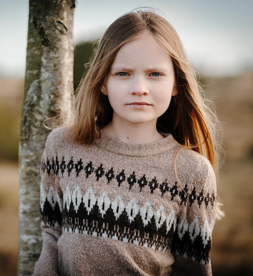 Portræt af pige udendørs fotograferet af fotograf i Aars med naturligt lys og ægte udtryk.