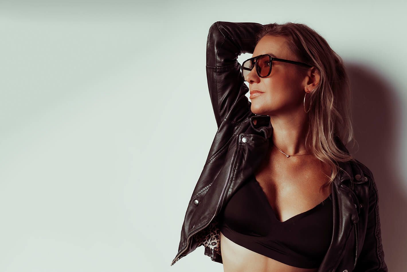 Model i solbriller og læderjakke – boudoirportræt med attitude og autenticitet..