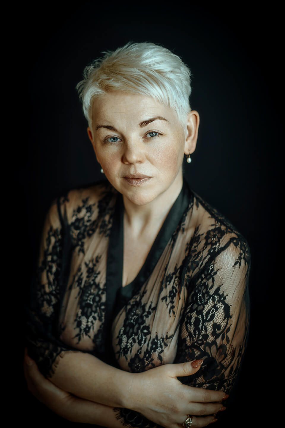 Sensuelt portræt af moden kvinde med kort blondt hår i sort blonde, fotograferet af boudoirfotograf i Aalborg.