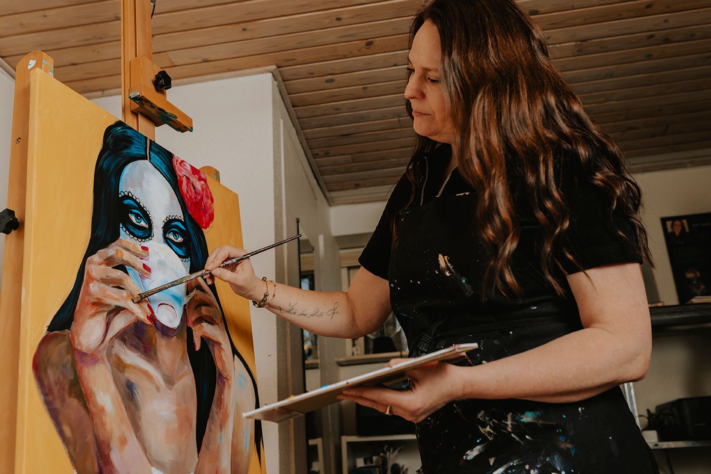 Portræt af kvindelig kunstner i atelier med pensel og lærred, taget af en fotograf i Aalborg.