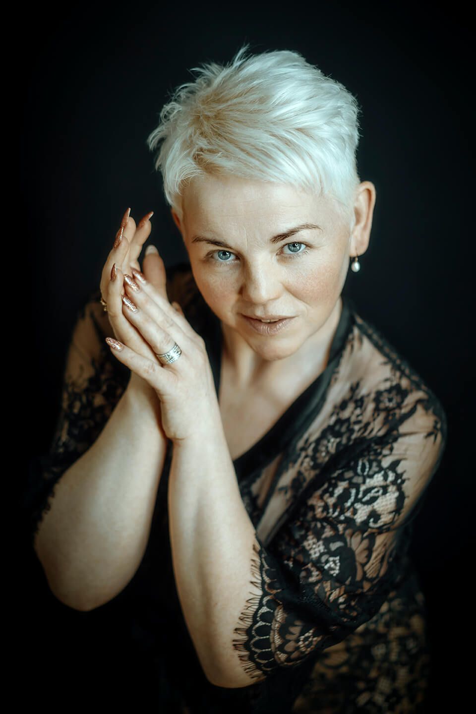 Sensuelt portræt af moden kvinde med kort blondt hår i sort blonde, fotograferet af boudoirfotograf i Aalborg.
