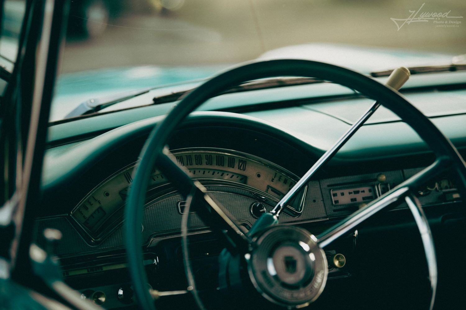 Vintage car dashboard interior showing classic gauges and steering wheel details.