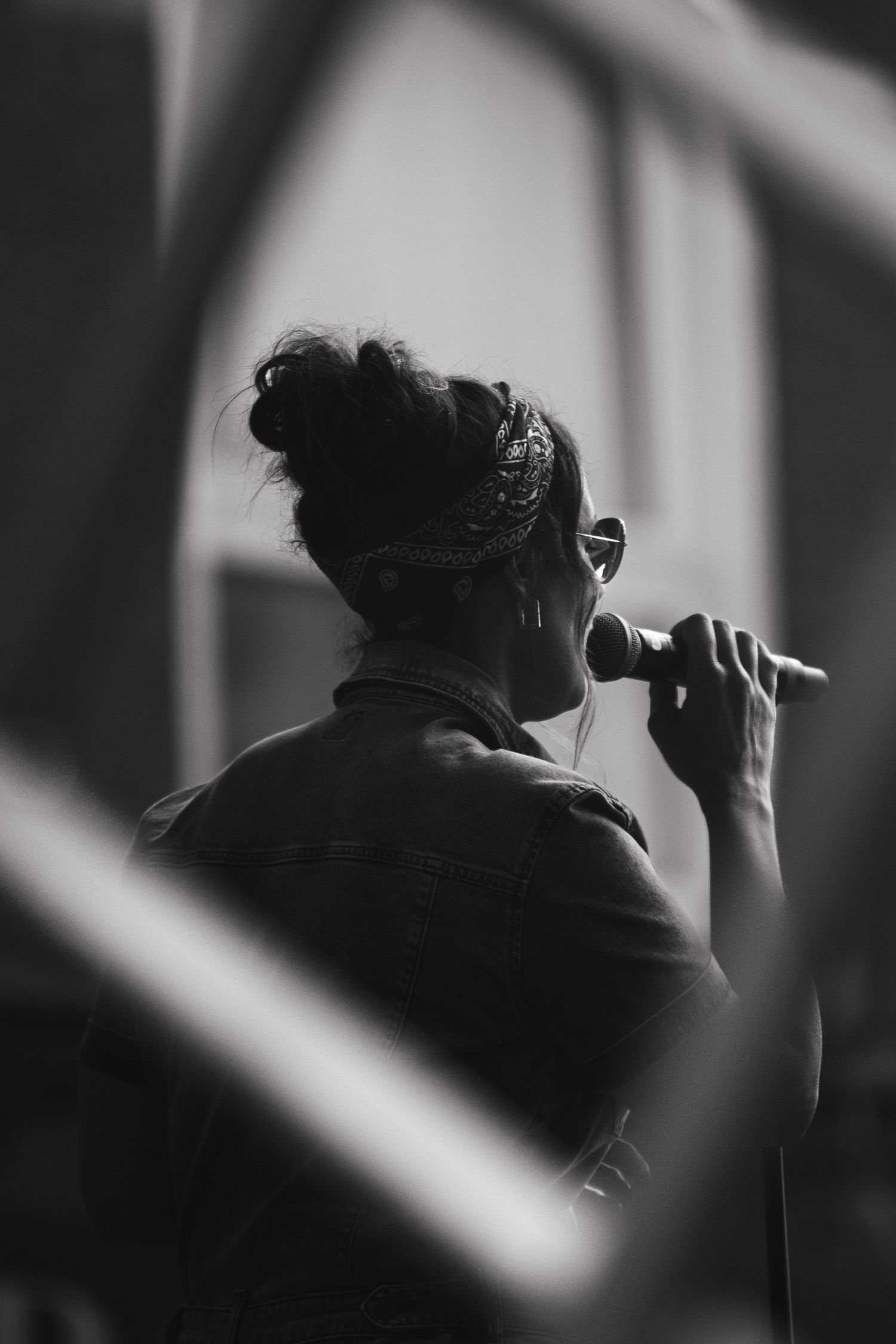 Black and white silhouette of a singer, singing into a microphone.