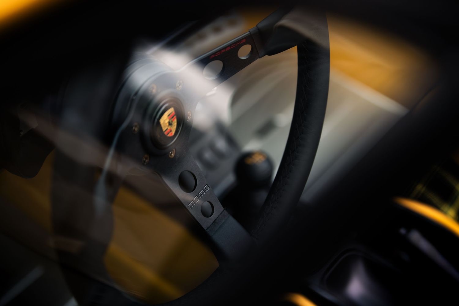 Close-up detail of a black steering wheel in dramatic lighting.
