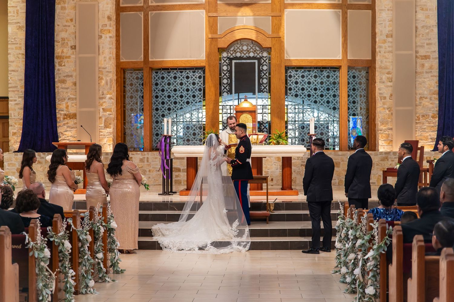 Wedding ceremony at a church altar with bride in white gown and groom in military dress uniform.
