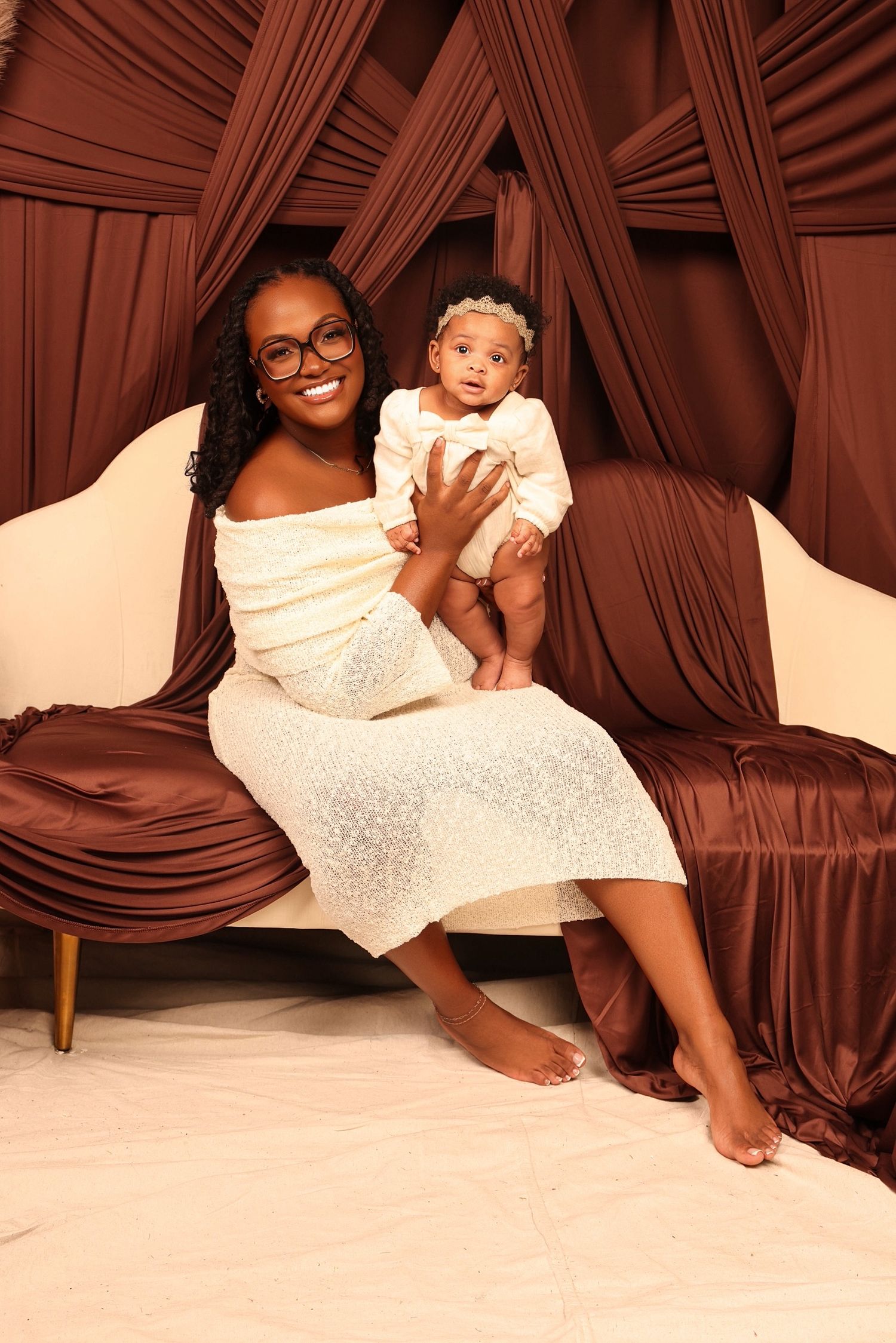 Lifestyle photos on white couch with brown draped fabric background.
