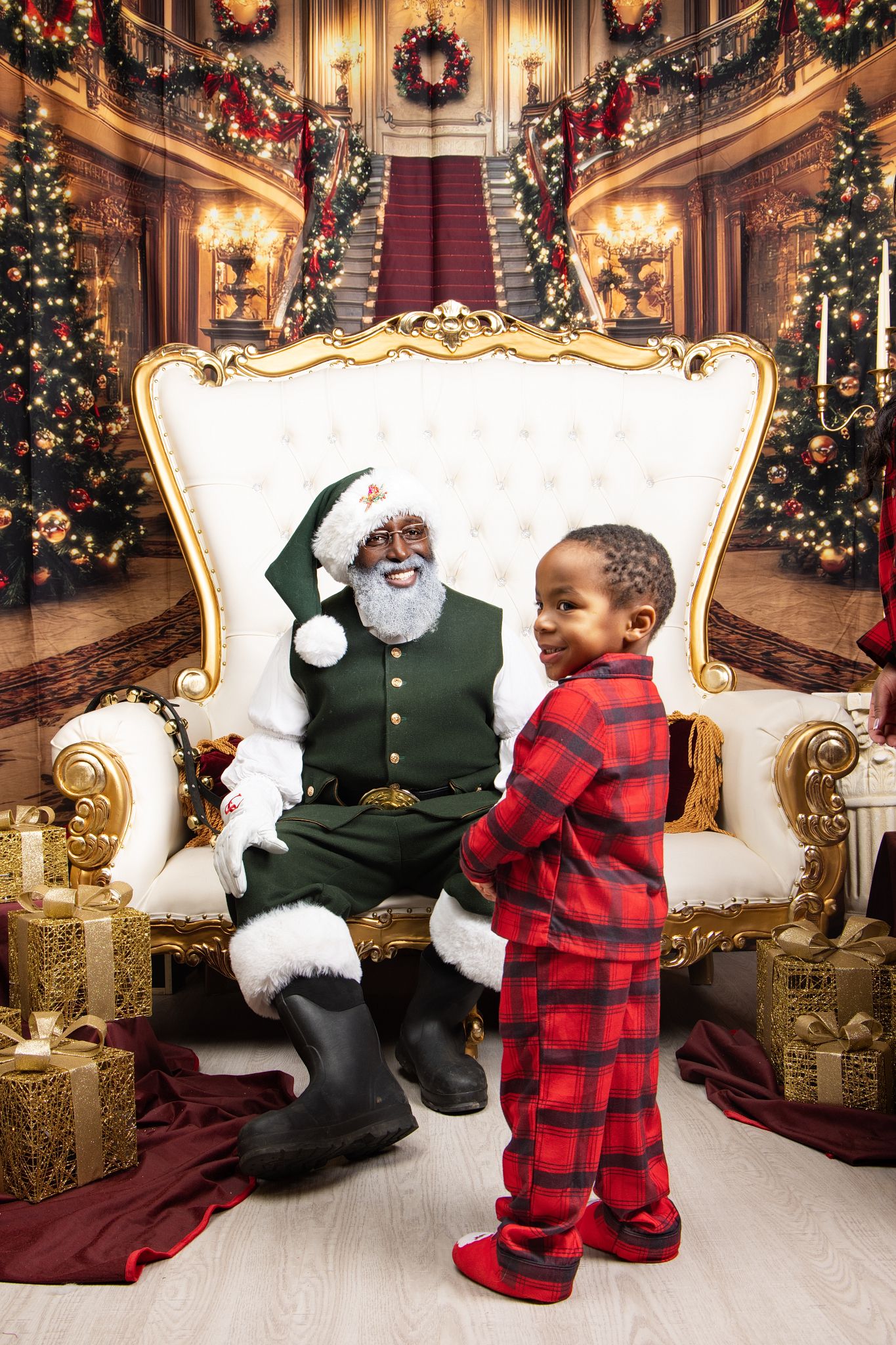 Children in matching buffalo plaid pajamas pose in an elegant Christmas setting with decorated trees and golden decor.