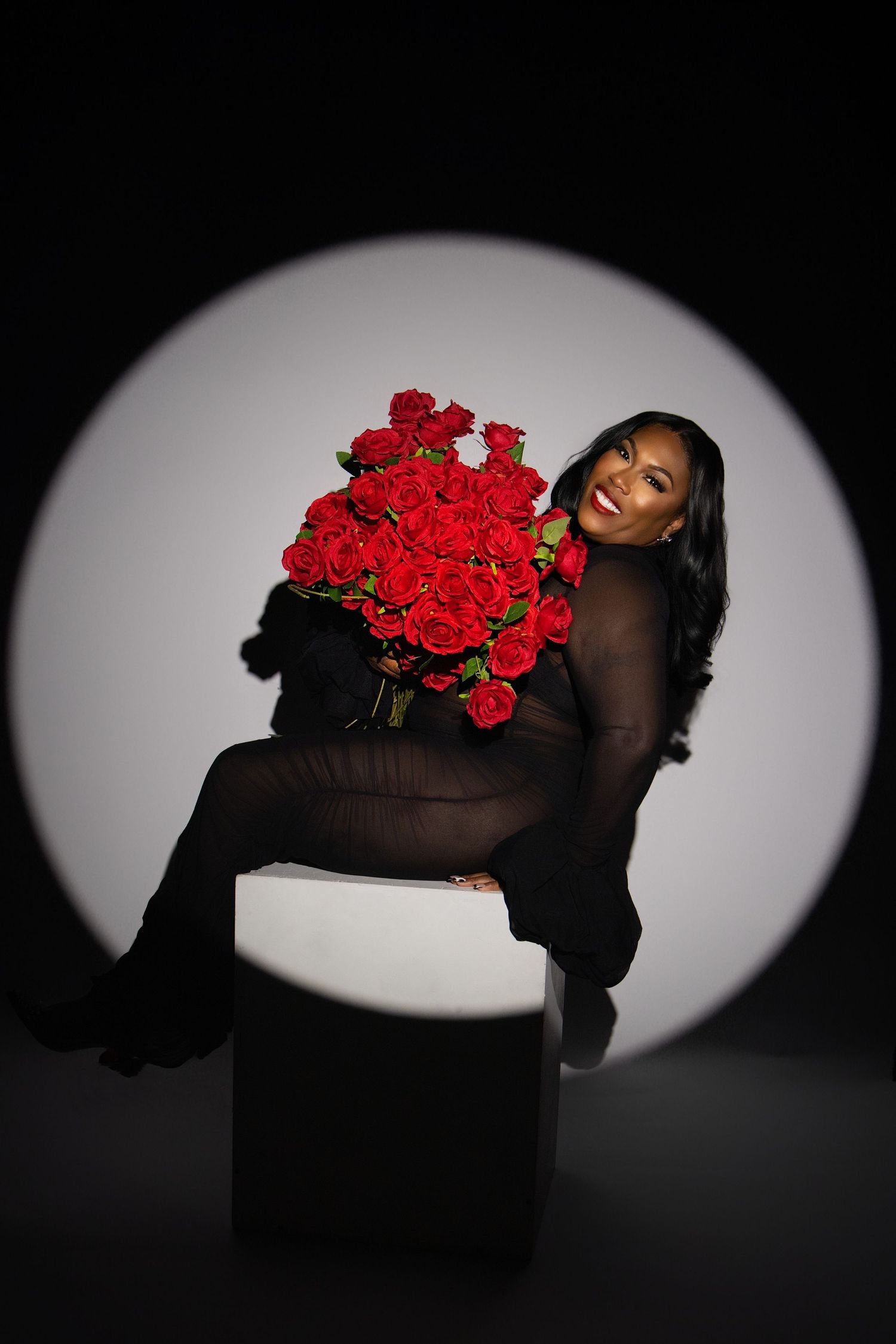 A dramatic sequence shows a person in black holding vibrant red roses against a dark background with oval vignette lighting.