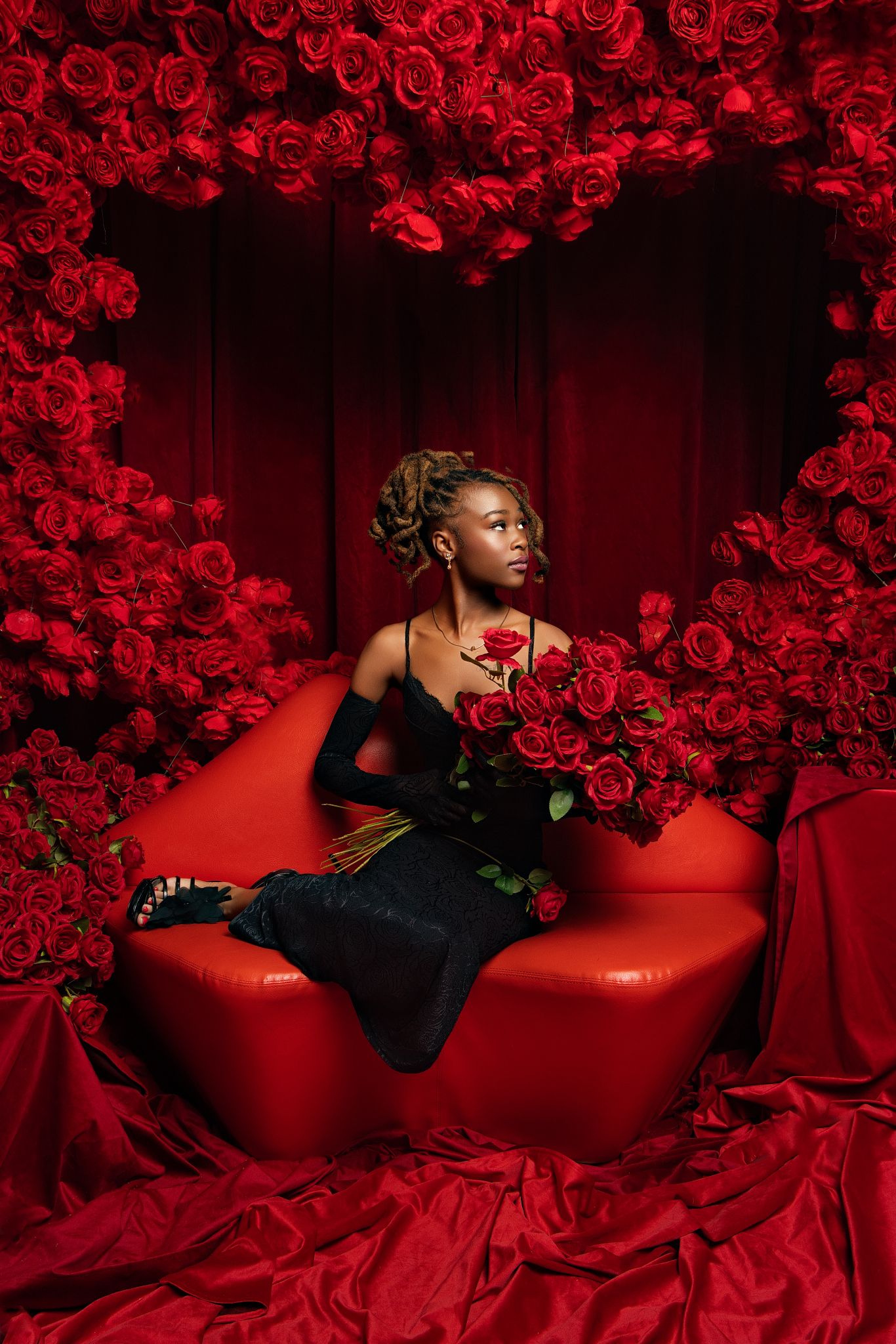 A series of artistic portraits showing a figure in black against a dramatic red backdrop with floral decorations.