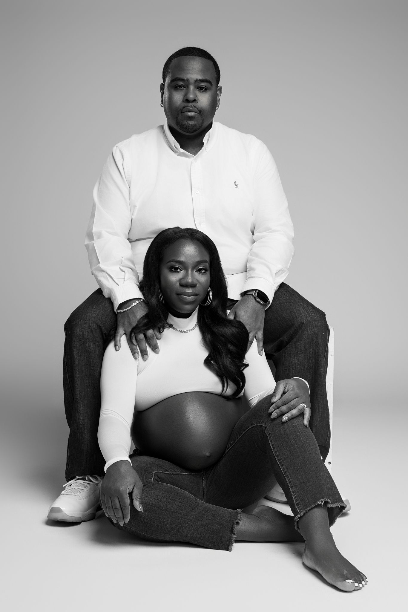 Maternity photoshoot series in black and white featuring a couple in contrasting white and black outfits.