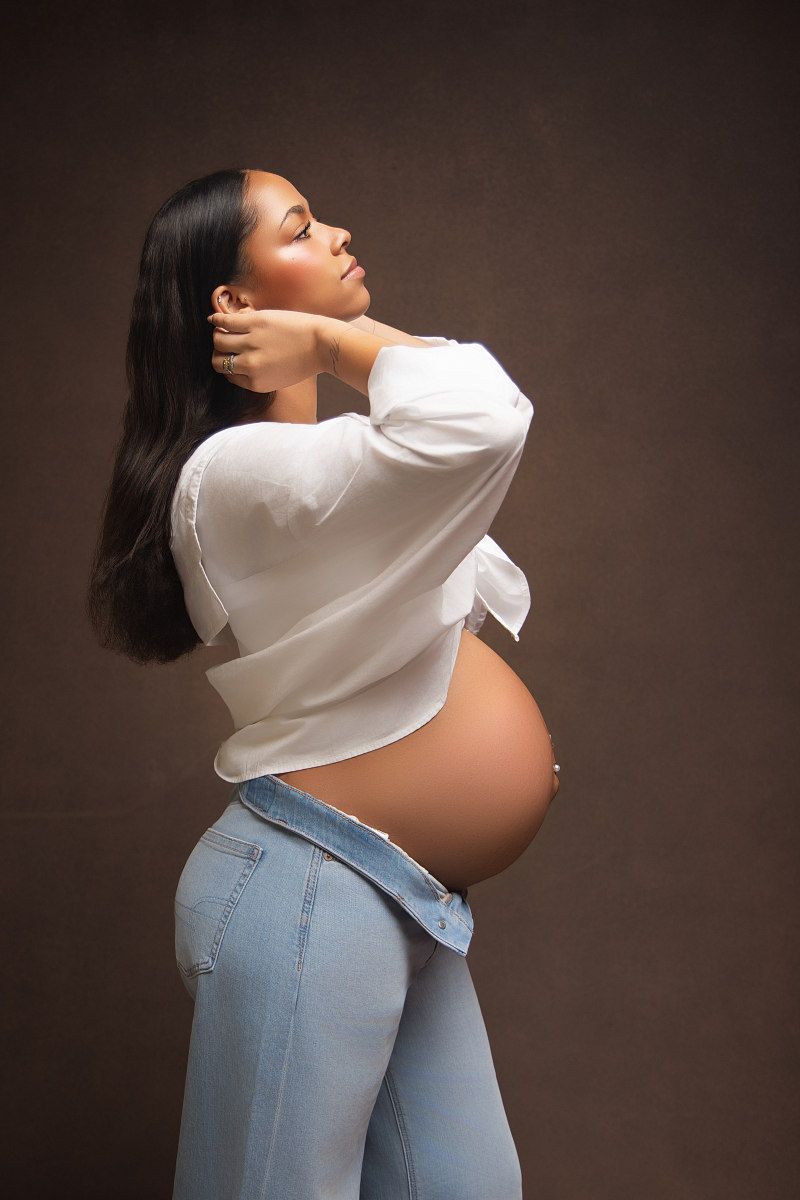 Artistic maternity photo series showing side profile poses in white top and jeans against dark background.
