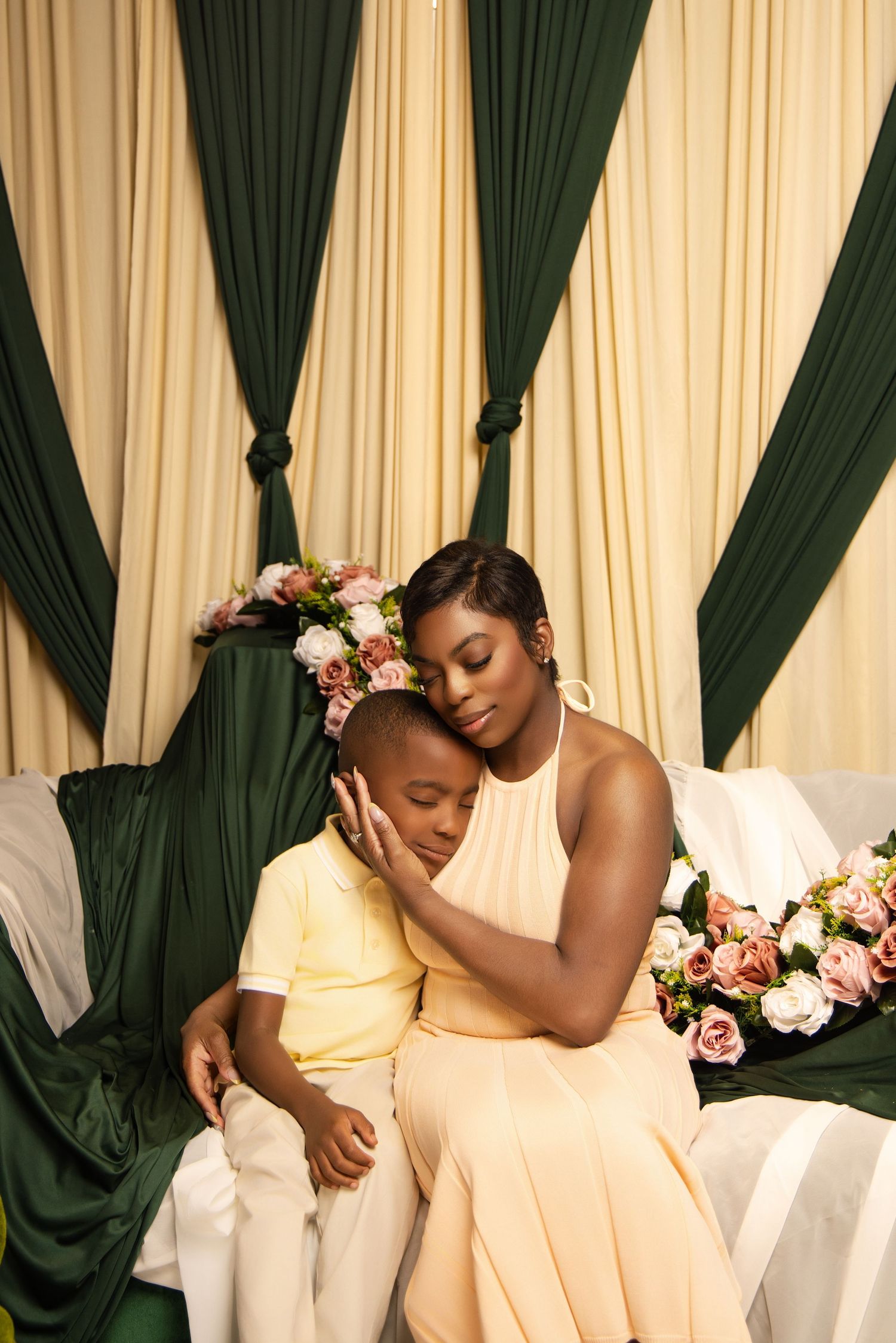 Beautiful portrait session with cream and forest green curtains and floral decorations.