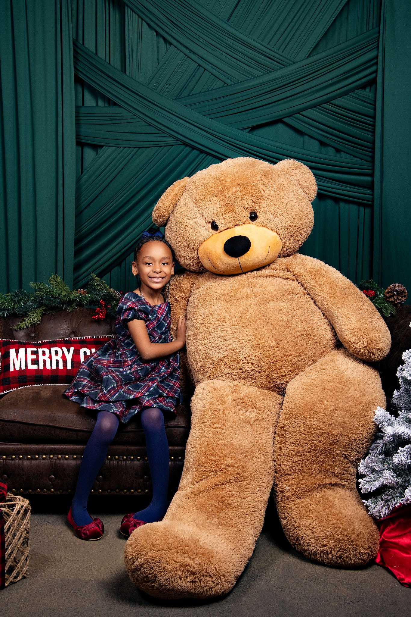 A large brown teddy bear sits on a couch with holiday decorations in a series of playful poses.