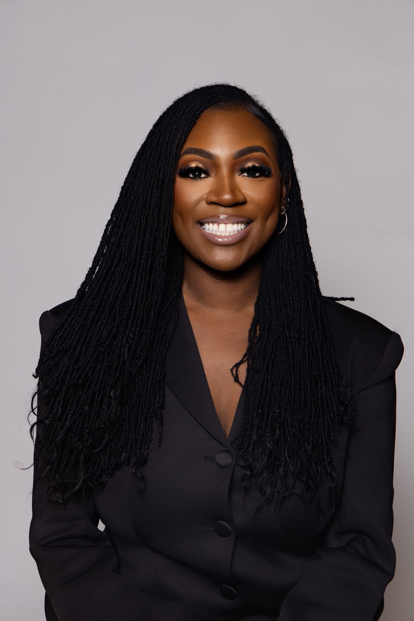 Professional headshot series featuring dark blazer and long braided hairstyle against gray background.