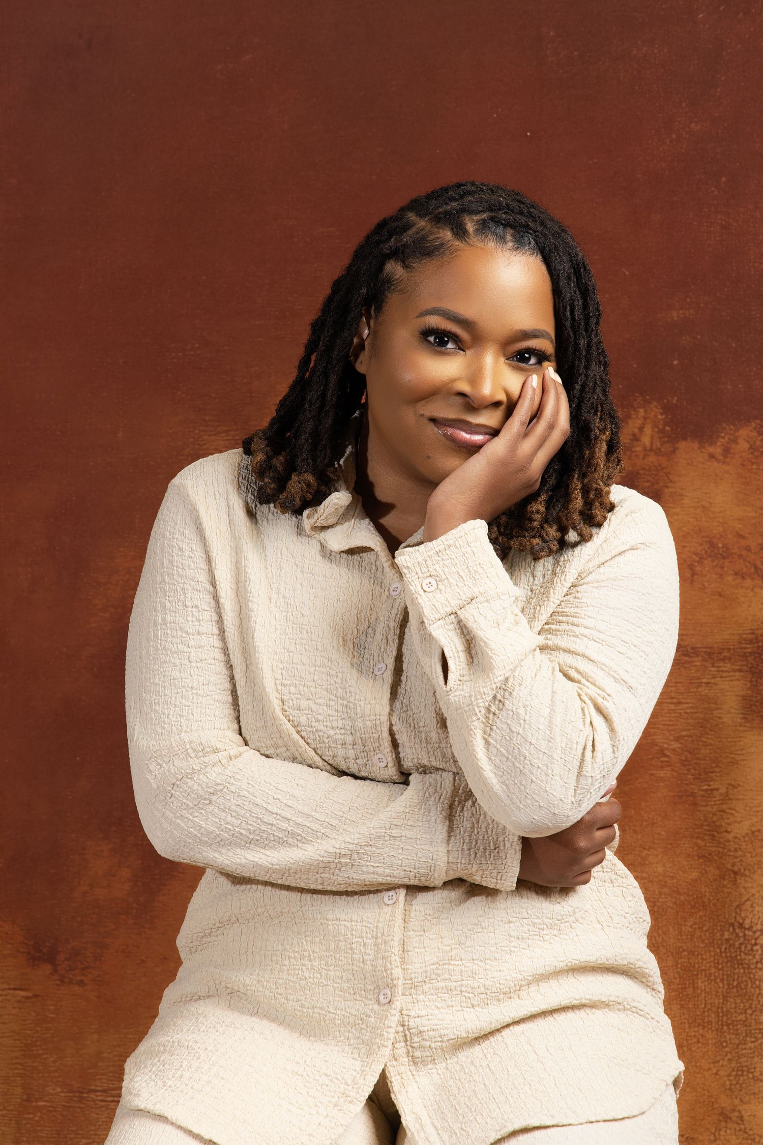 A series of five poses shows someone in a cream-colored sweater against a rustic brown background.
