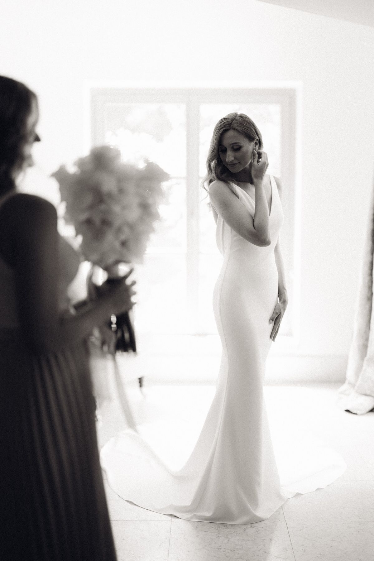 Bride being assisted with her dress, emotional and intimate preparation moment