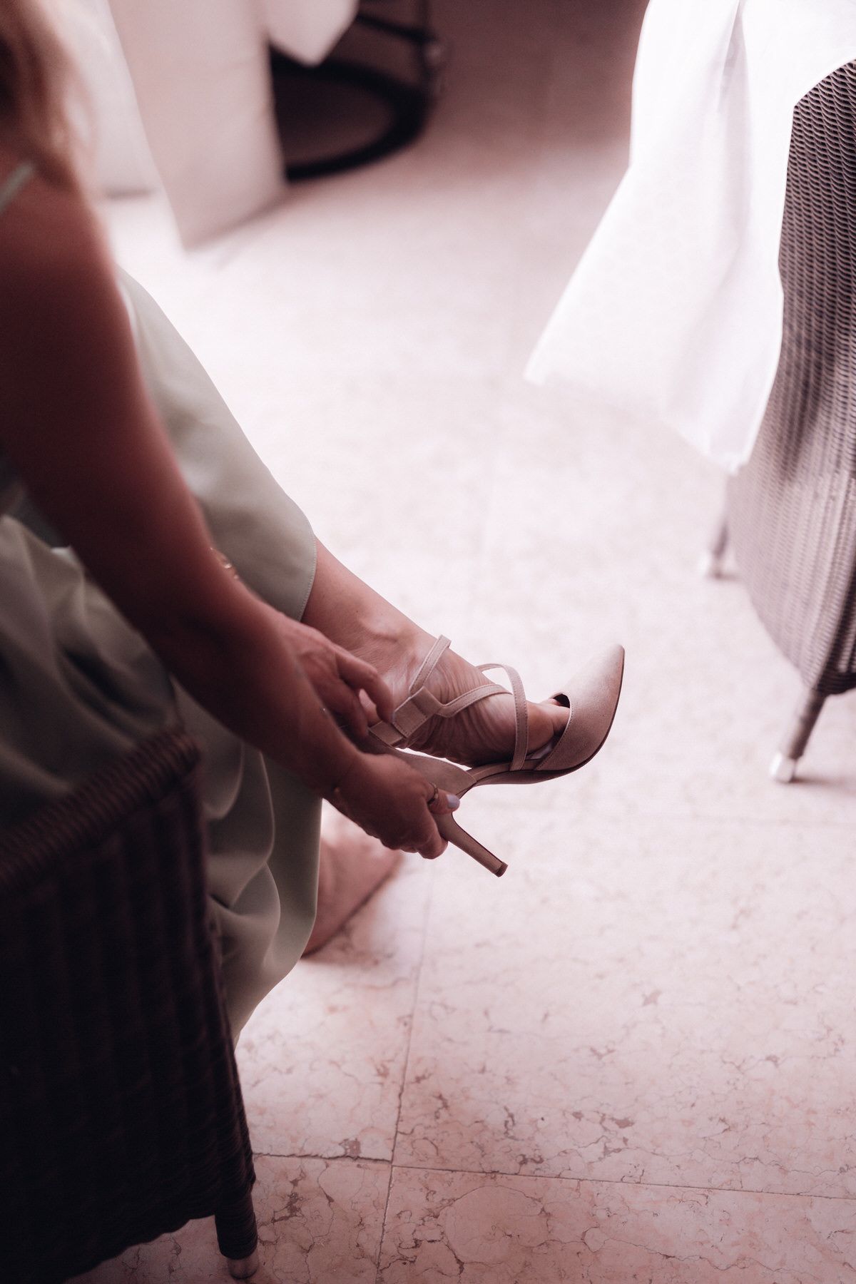 Bride putting on wedding shoes, close-up of final preparation detail