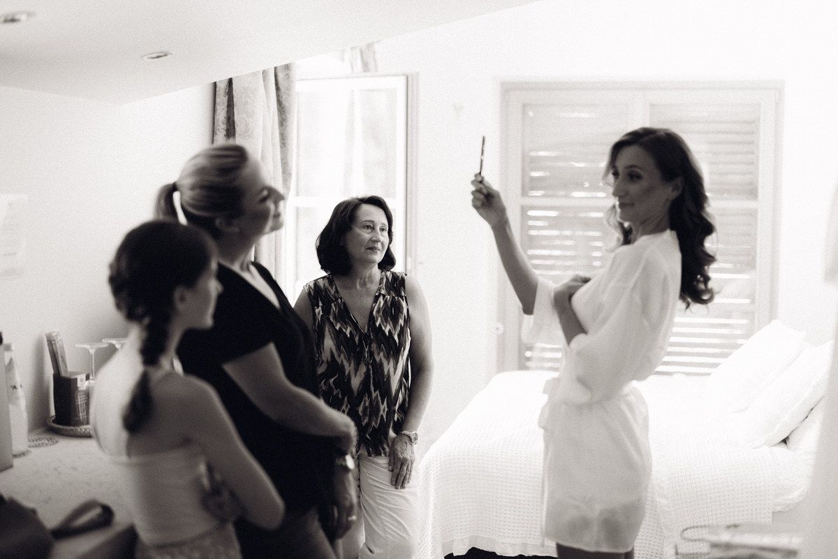 Bride laughing with bridesmaids during wedding preparations, candid and emotional moment
