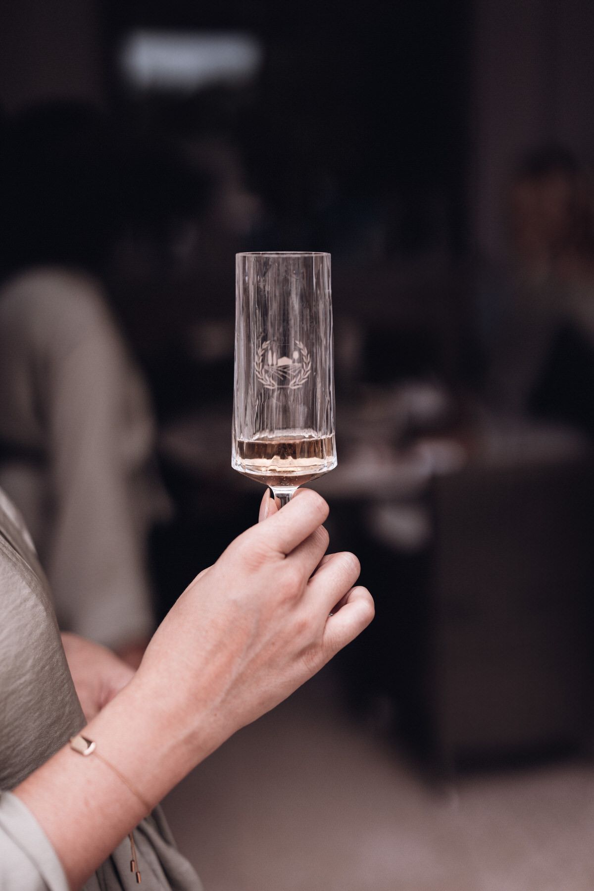 Bride holding a champagne glass, elegant celebration moment during wedding preparations