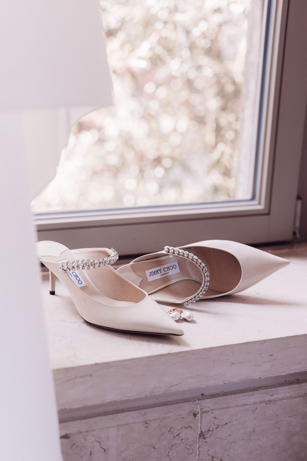 Bridal shoes placed by the window, soft daylight and minimalist wedding details