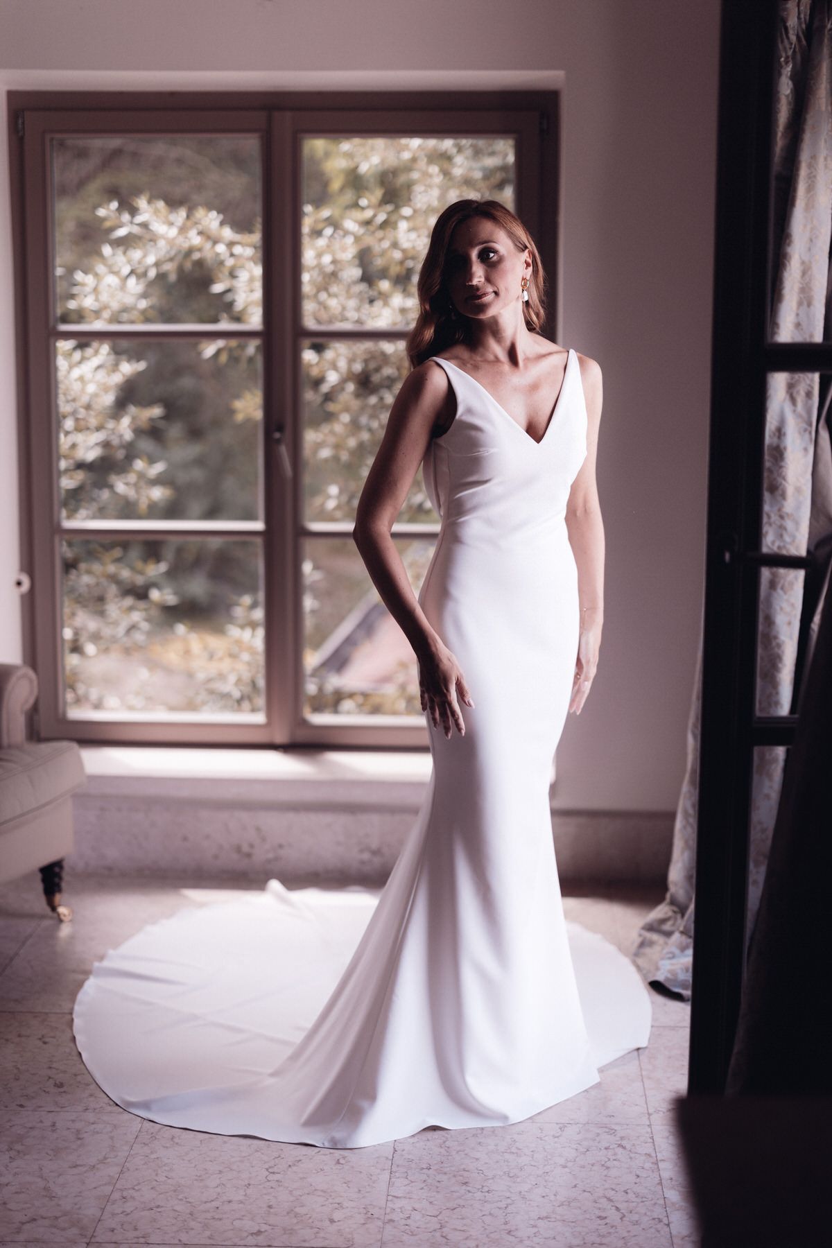Full-length bridal portrait in front of window, clean lines and natural light