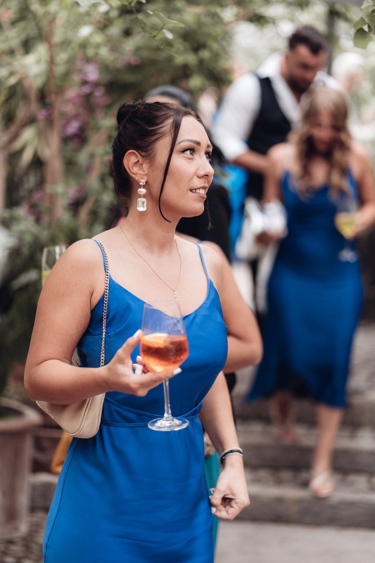 Hochzeitsgast lacht bei Sektempfang, lebendige Reportage einer Hochzeit in München.