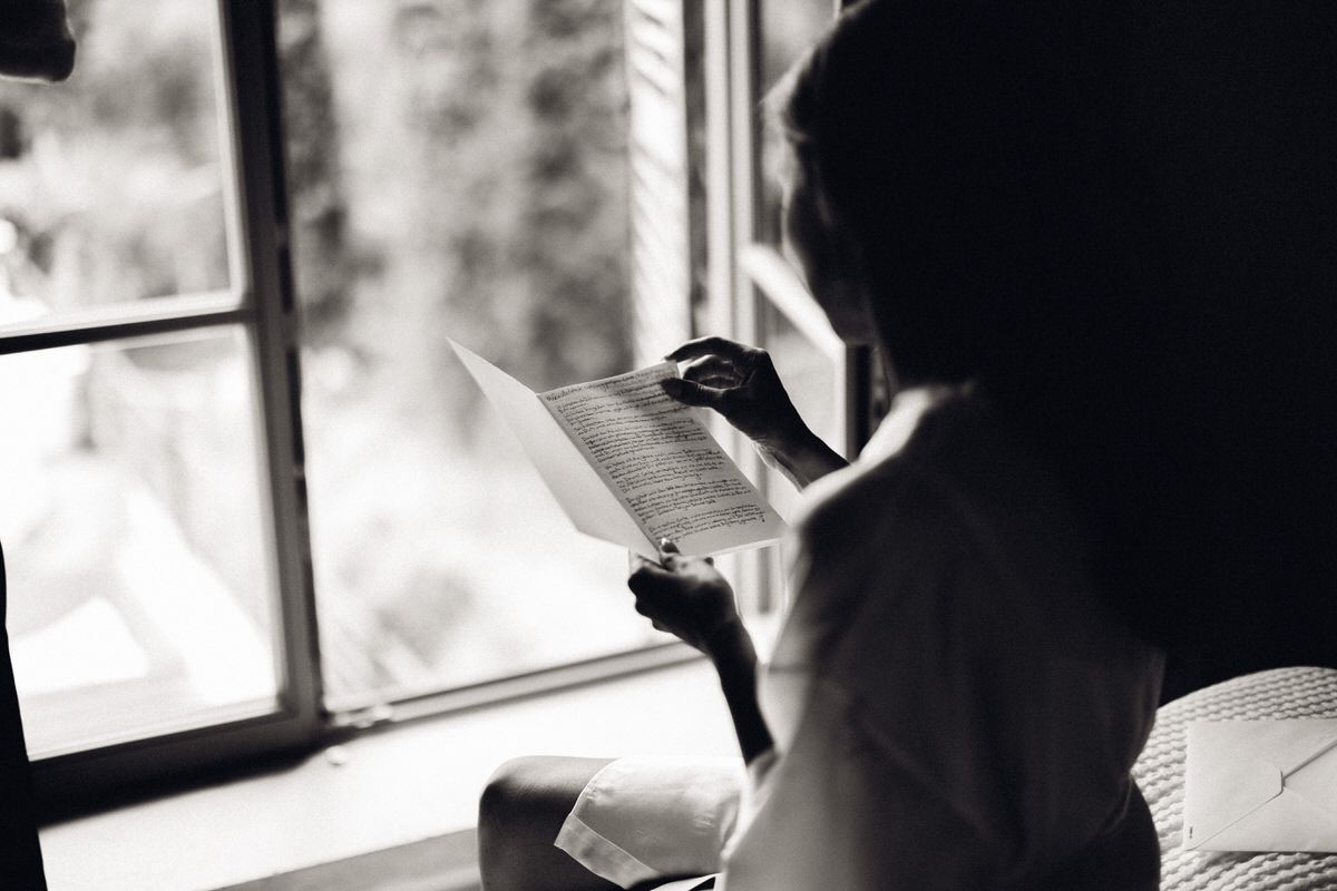 Bride by the window in black and white, reflective and intimate bridal portrait