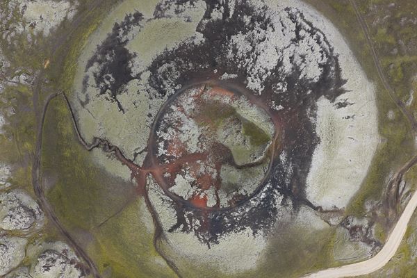 Abstract aerial patterns of snow and vegetation create natural textures across mountainous terrain.