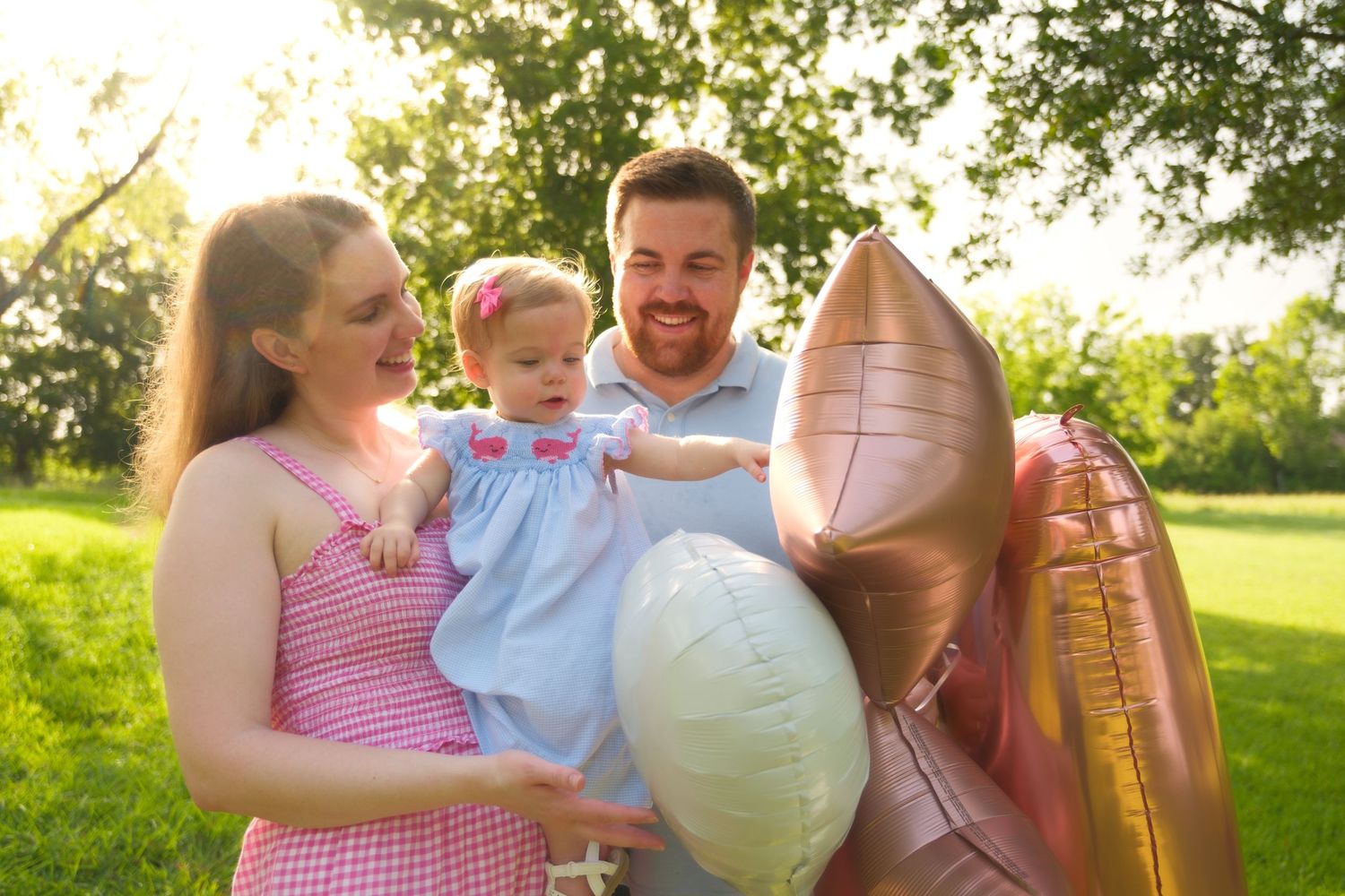 Mom and dad sharing baby's interest in balloons for family photos in Houston, Tx