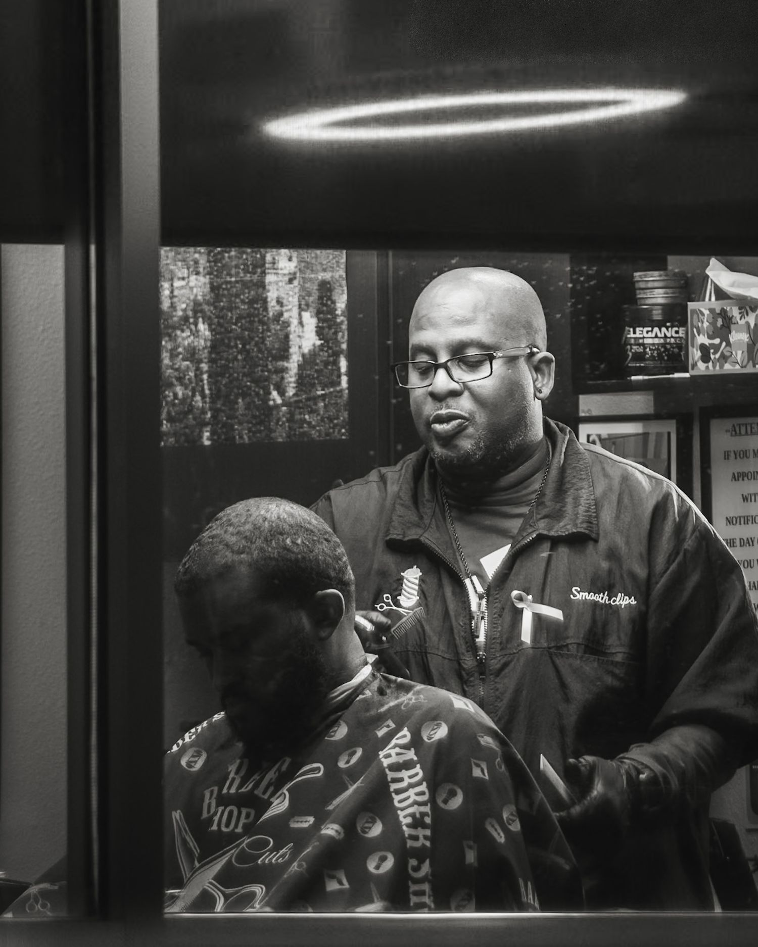 People in a barbershop setting captured through window at night. Captured by a Seguin photographer at grain n glass