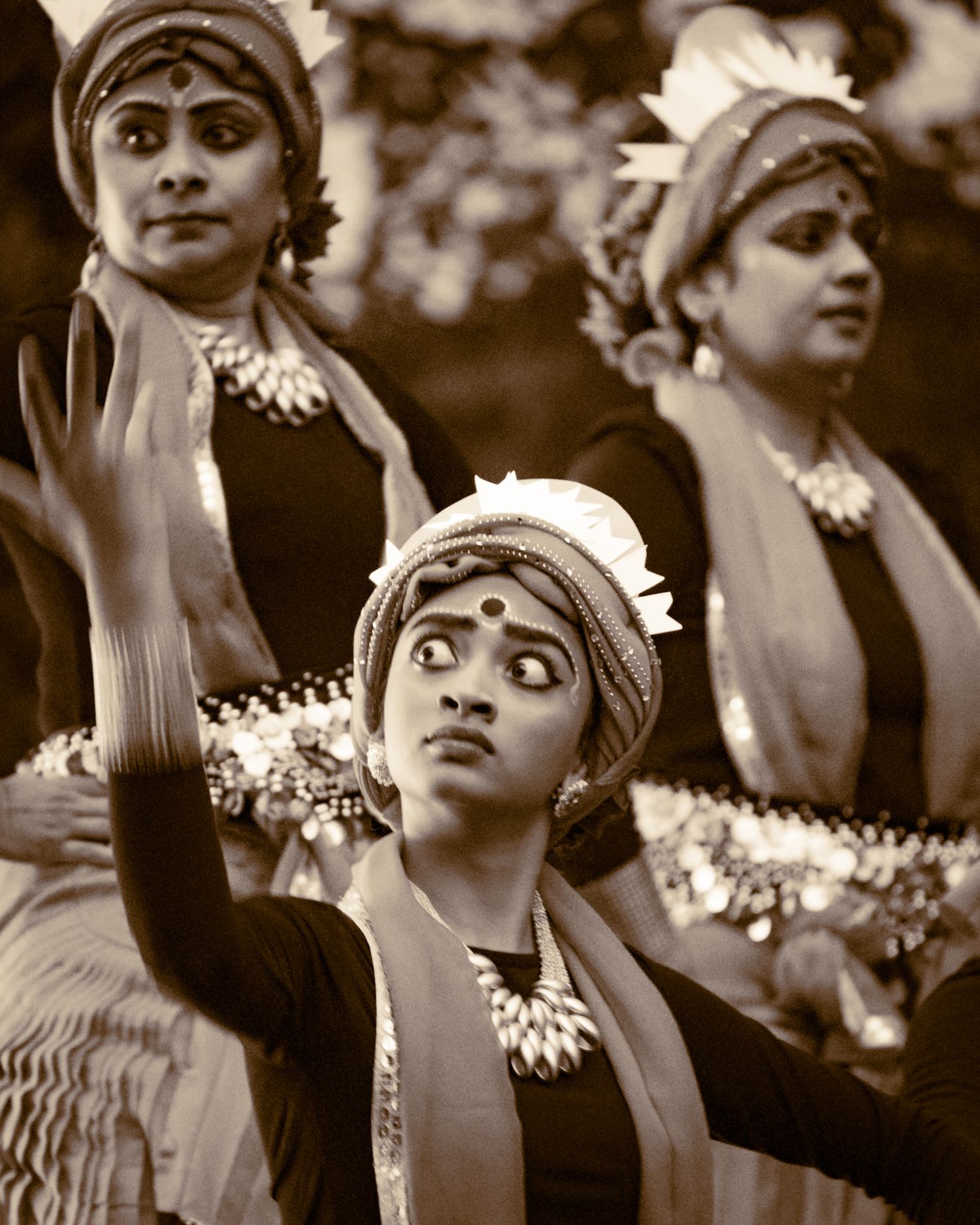 Dancers in vintage costumes perform traditional choreography in black and white.