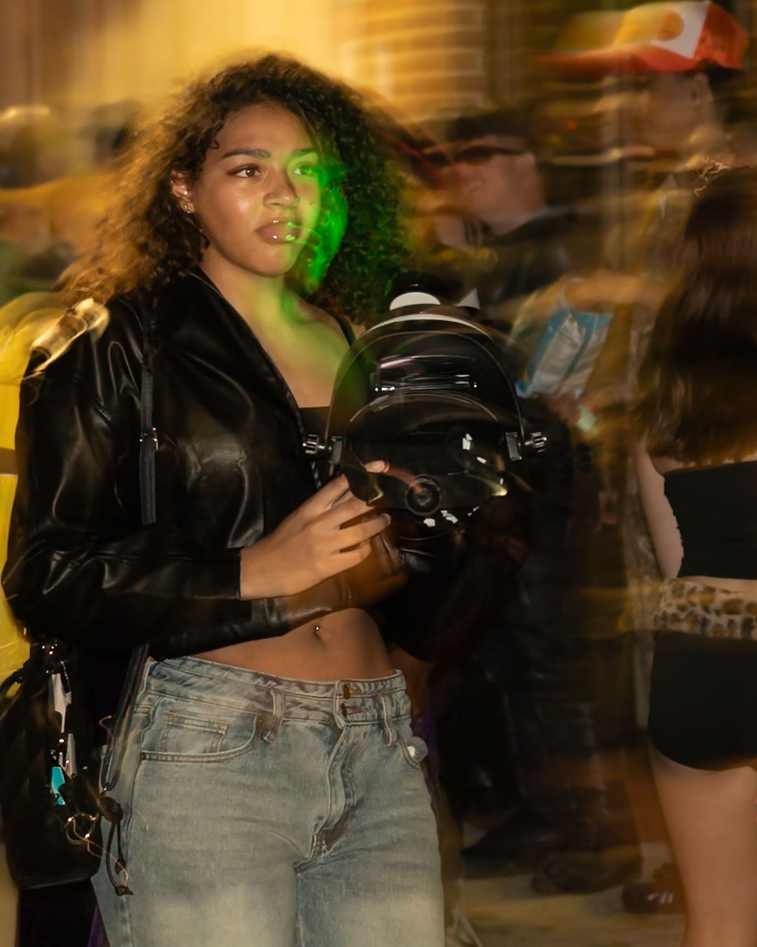Person dancing in a leather jacket and jeans under colorful club lighting. Captured by a Seguin photographer at grain n glass